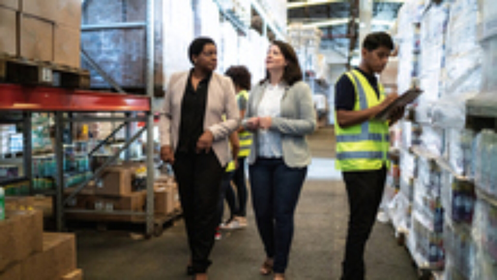 Coworkers talking while walking in a warehouse