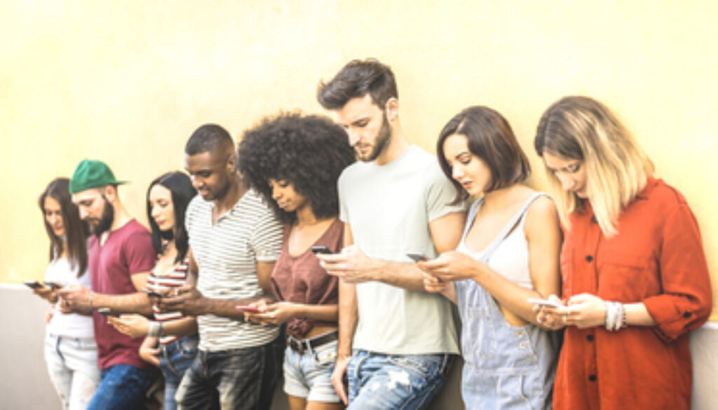 Multiracial friends using mobile smartphone at university coampus - Millenial people addicted by smart phones - Tech concept with always connected millennials on social networks - Bright warm filter