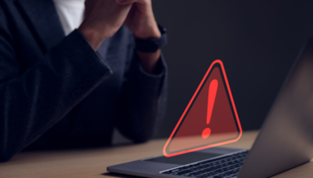 Computer notification error maintenance concept. Businessman or personnel, programmer, or developer using a computer laptop with a triangle warning exclamation red sign trouble caution.