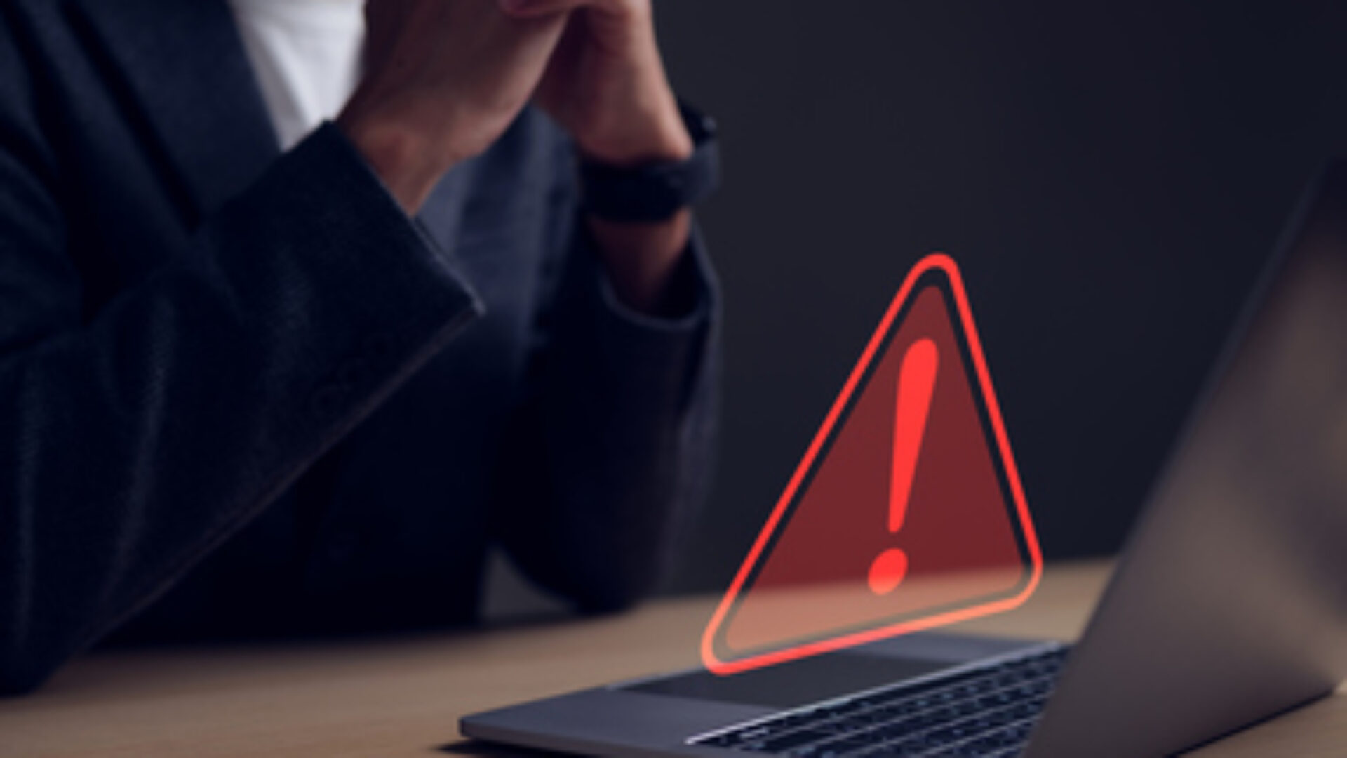 Computer notification error maintenance concept. Businessman or personnel, programmer, or developer using a computer laptop with a triangle warning exclamation red sign trouble caution.