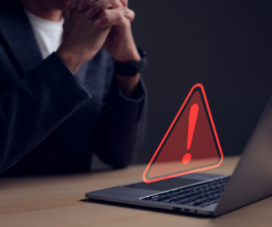 Computer notification error maintenance concept. Businessman or personnel, programmer, or developer using a computer laptop with a triangle warning exclamation red sign trouble caution.