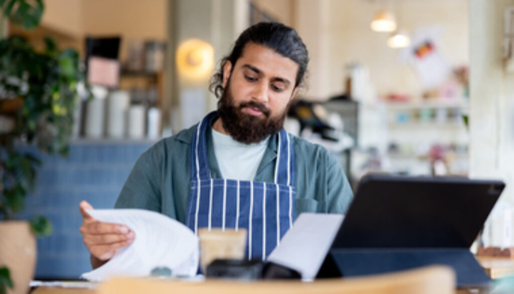 Coffee shop manager checking bills while doing the accountancy