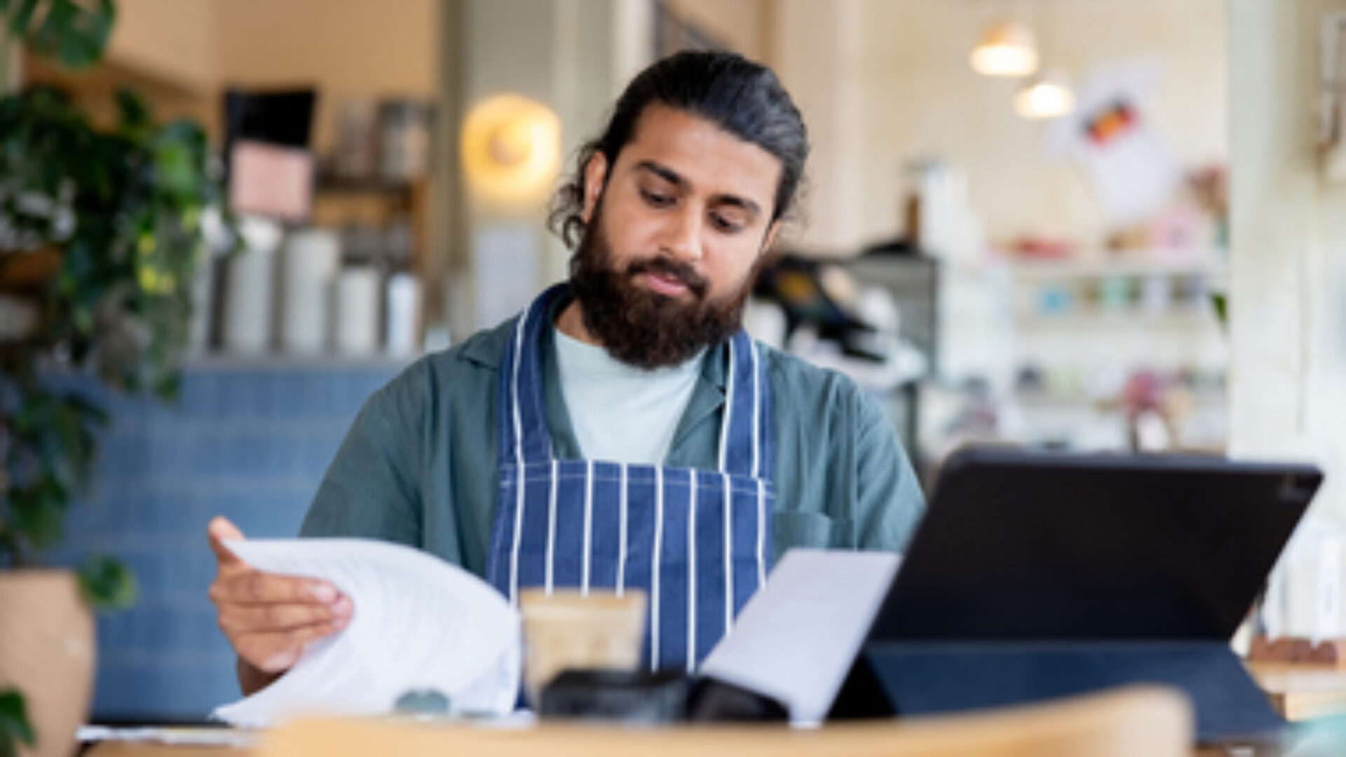 Coffee shop manager checking bills while doing the accountancy