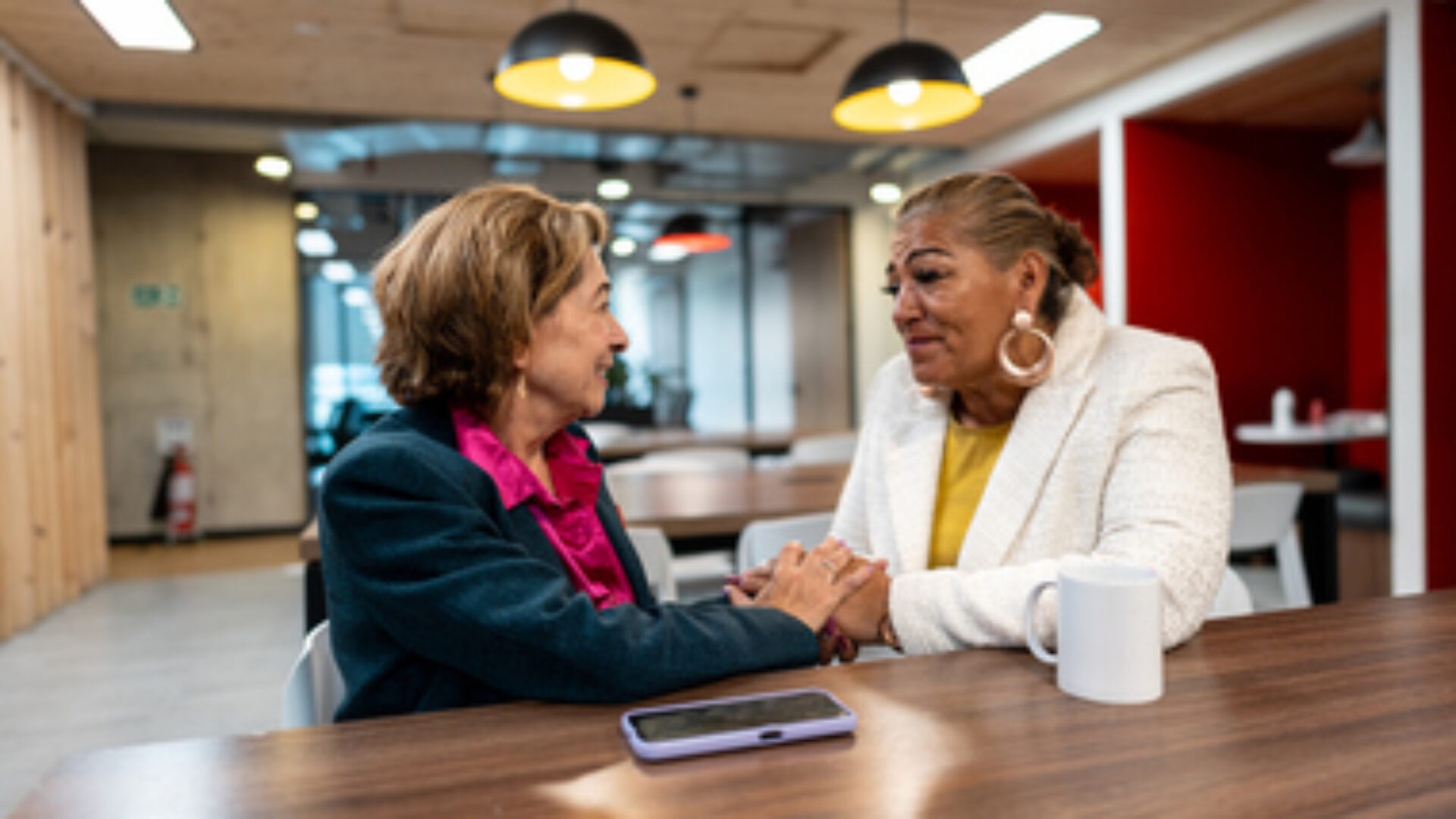 Senior businesswoman consoling coworker in the office