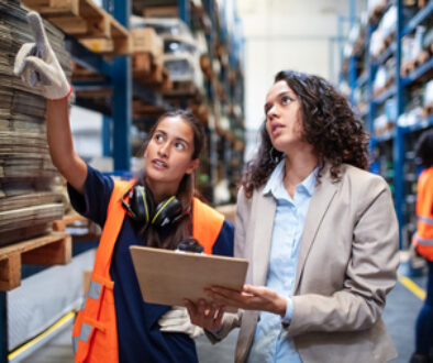 Warehouse manager with worker taking stock