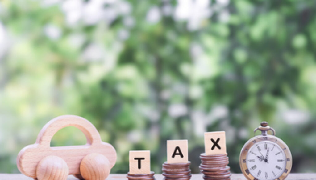 Vintage watch, Wooden toy car and wooden blocks with the word TAX on stack of coins. The concept of saving for paying tax. Manage time to success transportation, Car loan