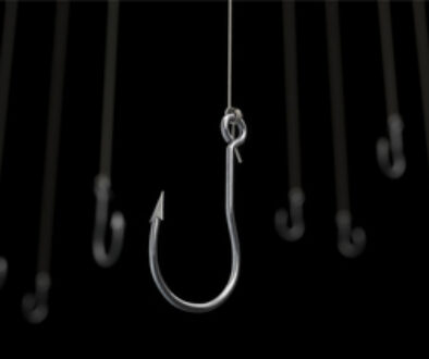 Many fishing hooks against a black background