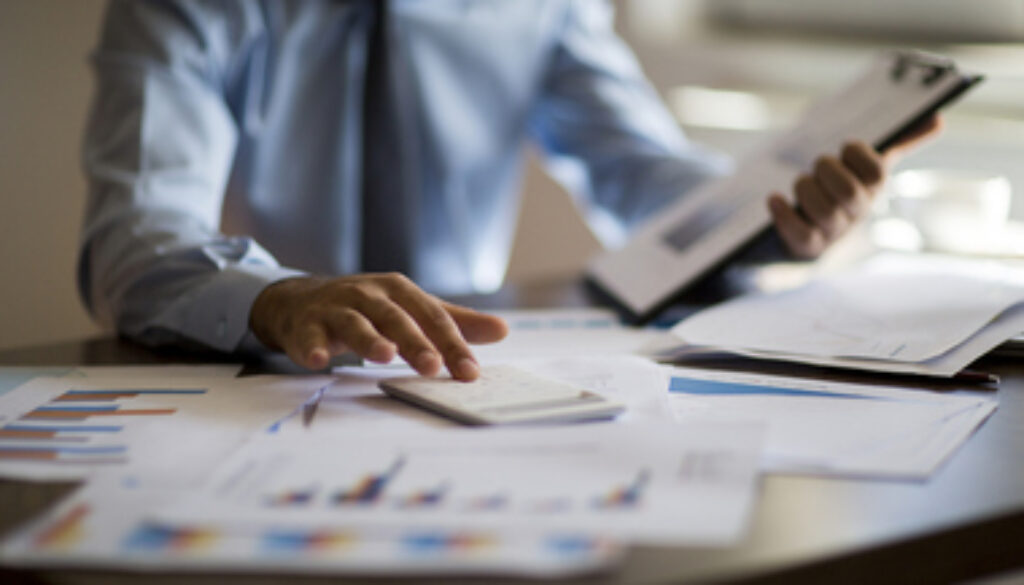 Business accounting concept, Business man using calculator with computer laptop, budget and loan paper in office.