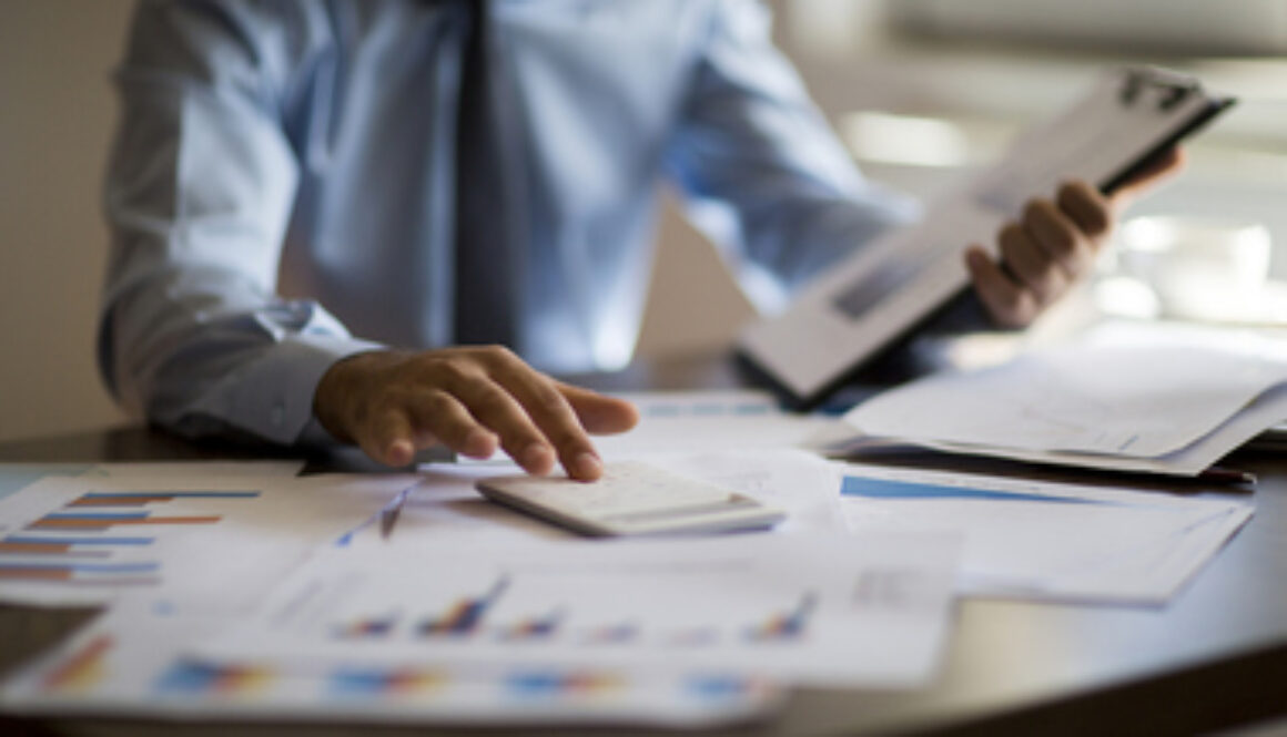 Business accounting concept, Business man using calculator with computer laptop, budget and loan paper in office.