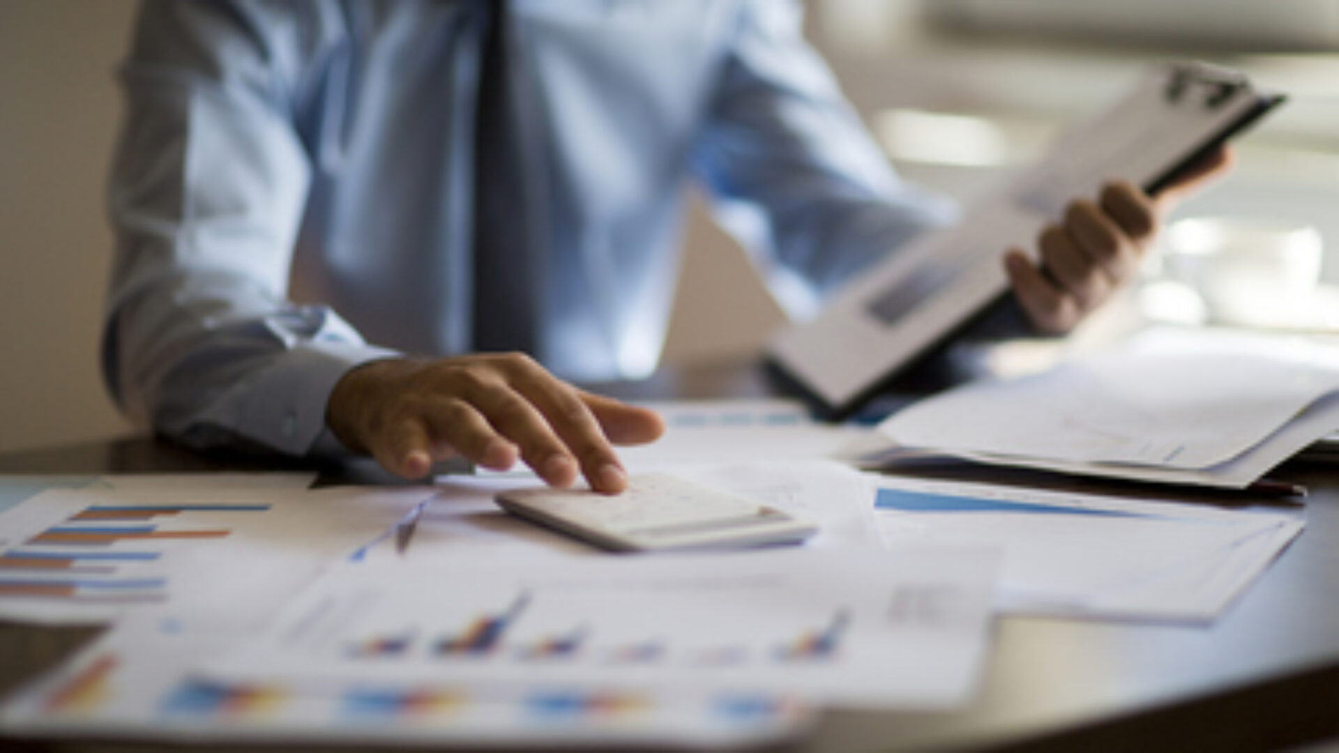 Business accounting concept, Business man using calculator with computer laptop, budget and loan paper in office.