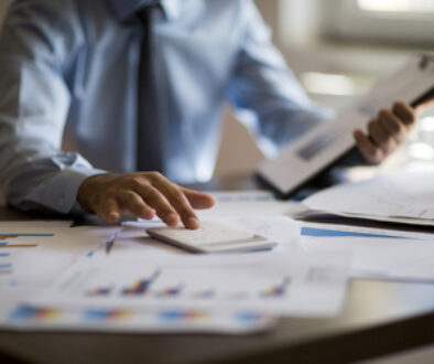 Business accounting concept, Business man using calculator with computer laptop, budget and loan paper in office.