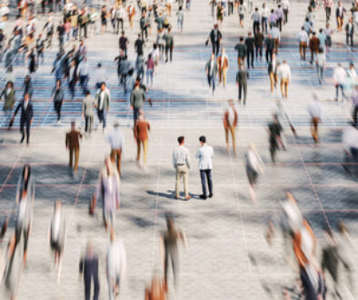 Businessmen on the street standing in crowds of walking people