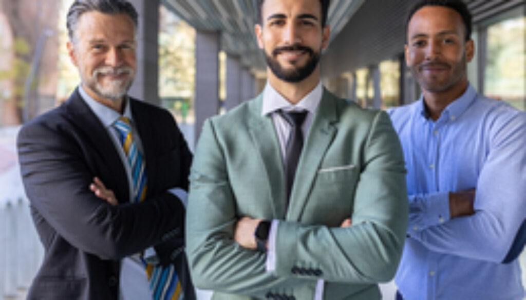 Successful portrait of corporate team of male colleagues looking at camera