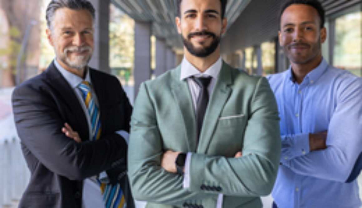 Successful portrait of corporate team of male colleagues looking at camera