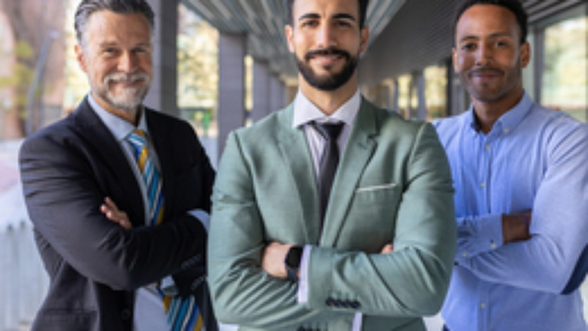 Successful portrait of corporate team of male colleagues looking at camera