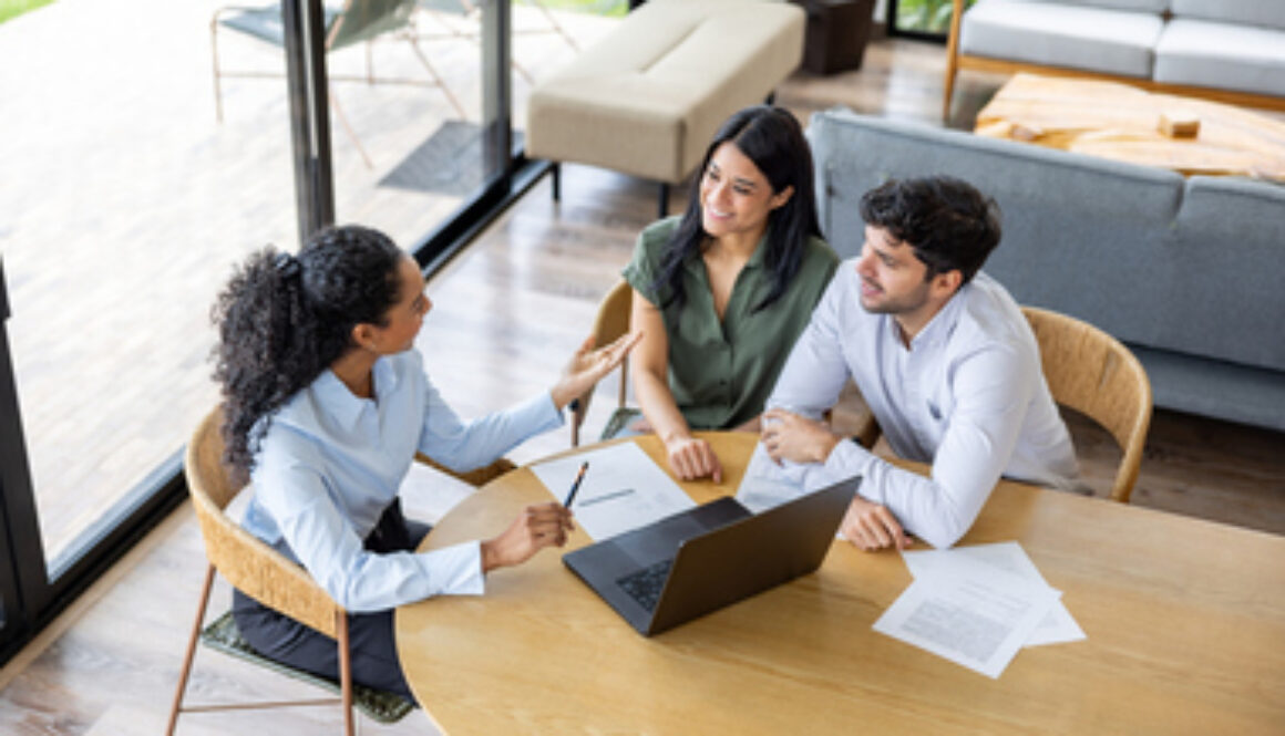 Real estate agent making a sales pitch to a couple buying a house