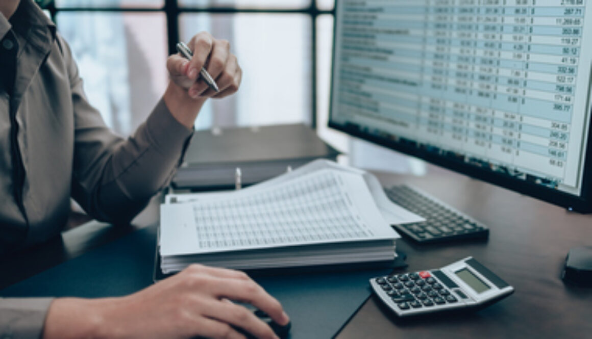 Investors working on desk office and check data cost, balance, profit and currency on monitor screen. Accounting and Financial concept.