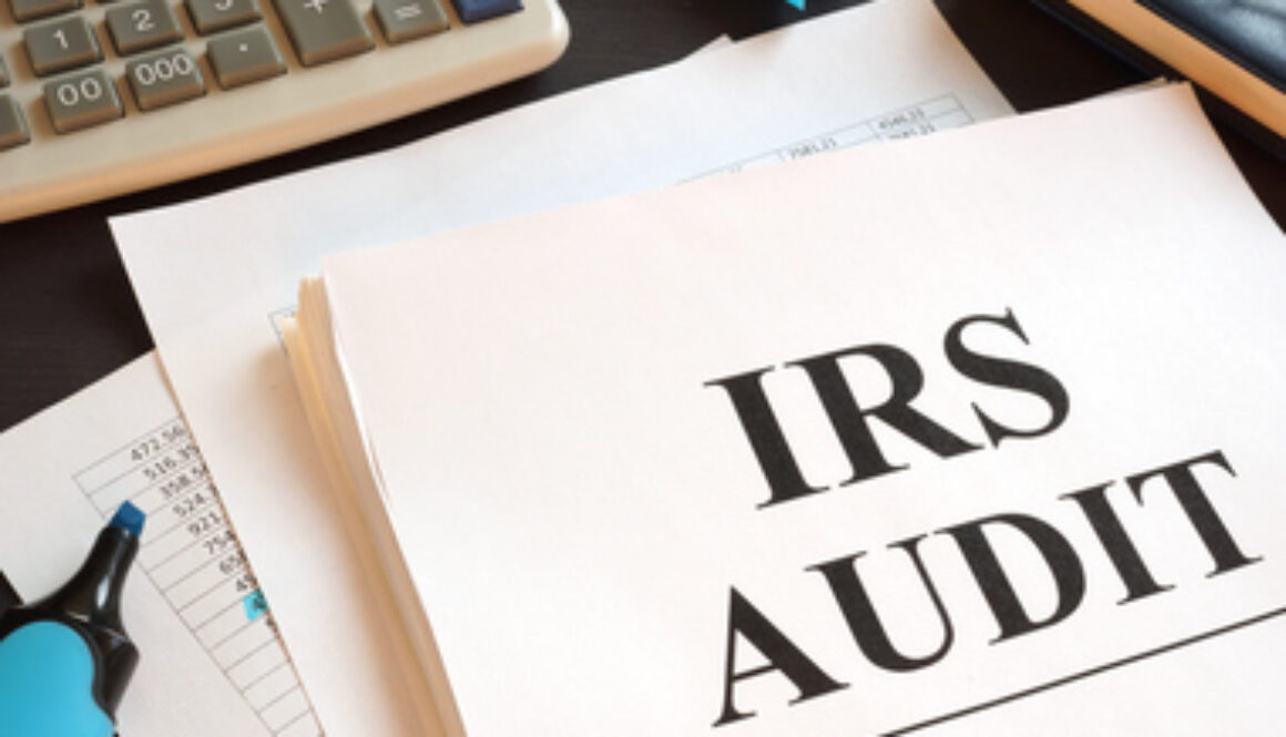 IRS Audit report and calculator on a desk.