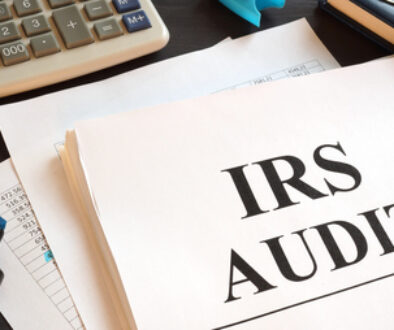 IRS Audit report and calculator on a desk.